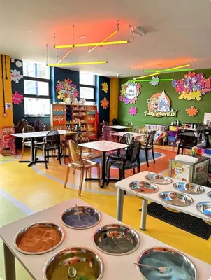 a classroom with tables and chairs and tables with food on them at Beatrice homes in Parkeston