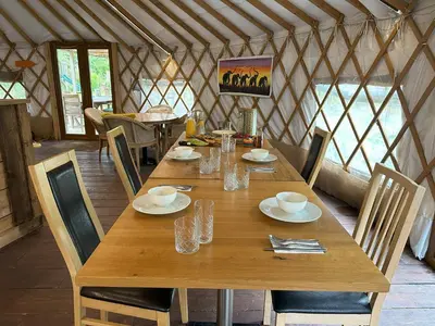 a wooden table in a yurt with a table and chairs at Potton Hall in Saxmundham