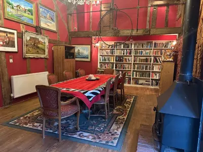 a red dining room with a table and chairs at Potton Hall in Saxmundham