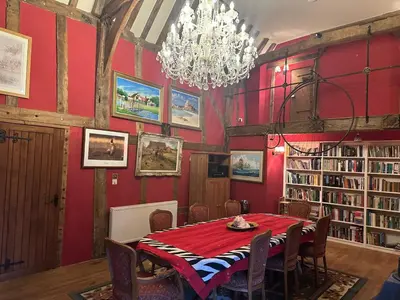 a dining room with a table and a chandelier at Potton Hall in Saxmundham