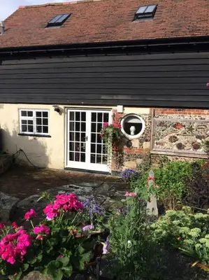a house with a window and flowers in front of it at The Garden Barn, Manuden nr Stansted in Manuden