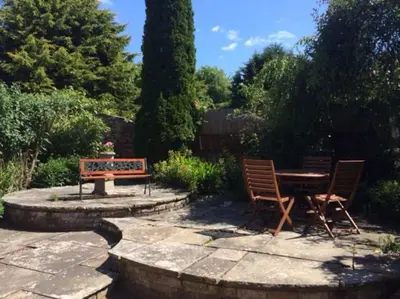 two chairs and a table and a bench in a garden at The Garden Barn, Manuden nr Stansted in Manuden