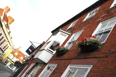 a red brick building with two windows with flowerpots at Short Stay Bungay in Bungay