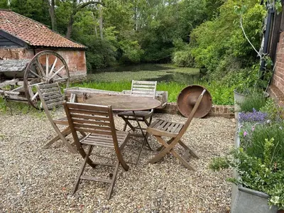 a wooden table and chairs in a garden at The Stables, Hasketon in Debach