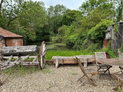 a couple of chairs and a wooden bench and a table at The Stables, Hasketon in Debach