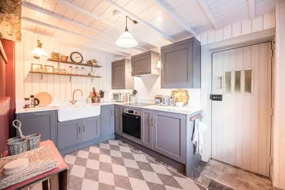 a kitchen with blue cabinets and a checkered floor at The Stables, Hasketon in Debach