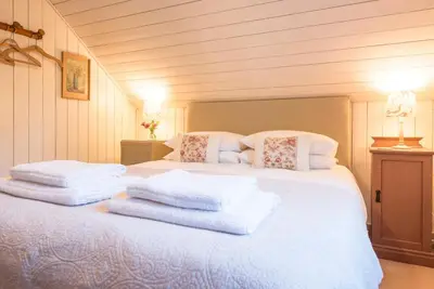 a bedroom with a bed with towels on it at The Stables, Hasketon in Debach
