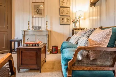 a living room with a blue couch and a fireplace at The Stables, Hasketon in Debach