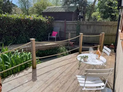 a wooden deck with a table and chairs on it at Little Brook Retreat in Chelmsford