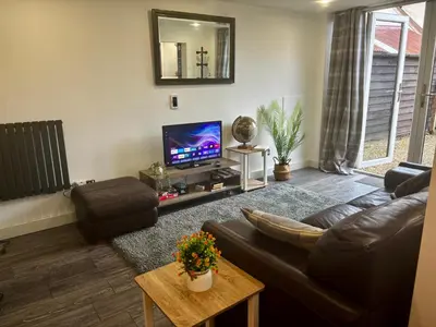 a living room with a couch and a tv at Little Brook Retreat in Chelmsford
