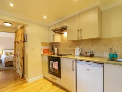 a kitchen with white cabinets and a counter top at Oakleaves in Colchester