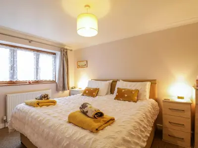 a bedroom with two dogs laying on a bed at Oakleaves in Colchester