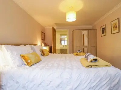 a bedroom with a large white bed with yellow pillows at Oakleaves in Colchester