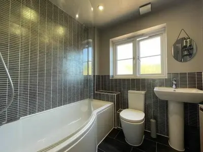 a bathroom with a tub and a toilet and a sink at 4br 2bath Home In Colchester Perfect For Big Group in Mile End