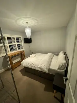 a bedroom with a white bed and a chandelier at 4br 2bath Home In Colchester Perfect For Big Group in Mile End