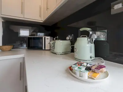 a kitchen counter with a tea kettle and a plate of food at Cosy Flat in Leigh Sea View - Pass the Keys in Southend-on-Sea