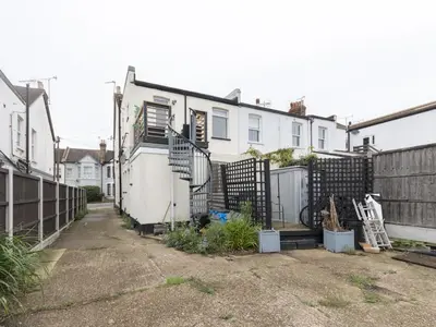 a row of white houses with a fence at Cosy Flat in Leigh Sea View - Pass the Keys in Southend-on-Sea