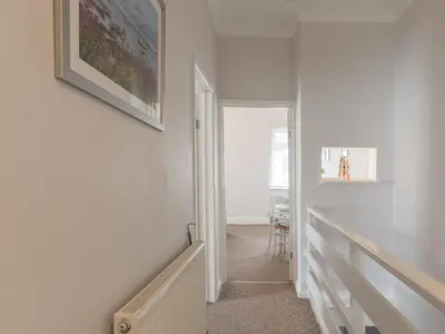 a hallway with a stairway with a picture on the wall at Cosy Flat in Leigh Sea View - Pass the Keys in Southend-on-Sea