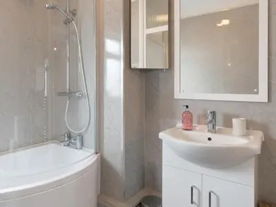 a white bathroom with a sink and a shower at Cosy Flat in Leigh Sea View - Pass the Keys in Southend-on-Sea