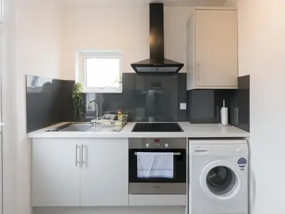 a kitchen with a sink and a washing machine at Cosy Flat in Leigh Sea View - Pass the Keys in Southend-on-Sea