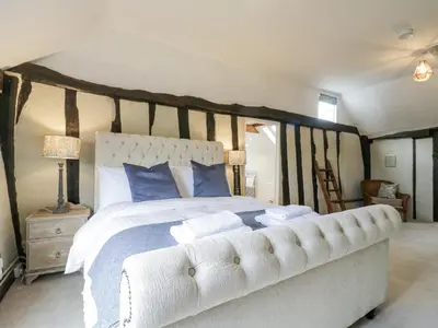 a bedroom with a large white bed with blue pillows at Knights Farm in Ipswich