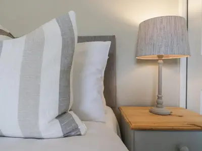 a bed with a pillow and a lamp on a night stand at Knights Farm in Ipswich