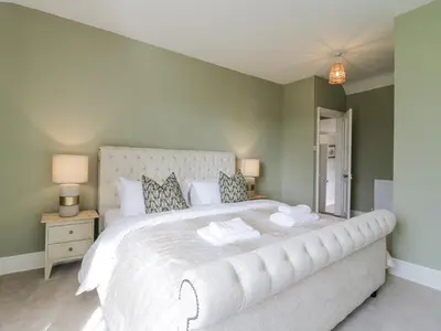 a bedroom with a large white bed with two pillows at Knights Farm in Ipswich