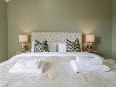 a white bed with two pillows and towels on it at Knights Farm in Ipswich