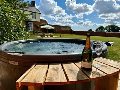 a bottle of wine sitting on a table next to a hot tub at Knights Farm in Ipswich