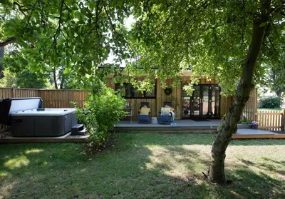 a backyard patio with a slow cooker in the yard at Copper Beech Lodge with Hot Tub, Games Room, Fire Pit in Toppesfield