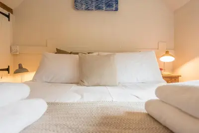 a bedroom with a white bed with white pillows at Blythburgh Cottage, Yoxford in Yoxford