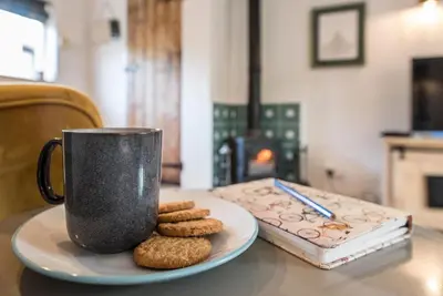 a plate of cookies and a coffee cup on a table at Blythburgh Cottage, Yoxford in Yoxford