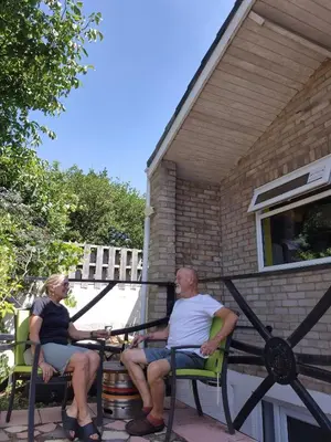 a man and a woman sitting on a porch at Secret Bunker at Vikings Forge in Bury Saint Edmunds