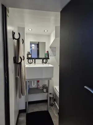 a bathroom with a white sink and a mirror at Secret Bunker at Vikings Forge in Bury Saint Edmunds