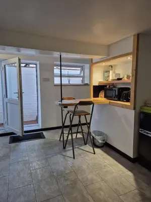 a small kitchen with a table and a chair at Secret Bunker at Vikings Forge in Bury Saint Edmunds