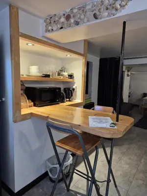 a kitchen with a wooden table and a microwave at Secret Bunker at Vikings Forge in Bury Saint Edmunds