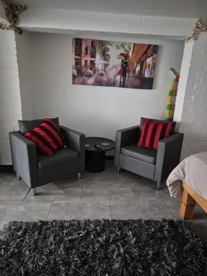 a living room with two chairs and a table at Secret Bunker at Vikings Forge in Bury Saint Edmunds