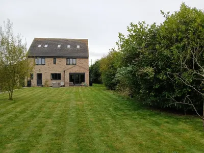 a house with a large yard in front of it at Woodlands Peaceful Bedrooms in Hemingford Grey