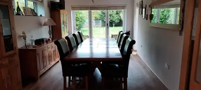 a dining room table with black chairs and a wooden table at Woodlands Peaceful Bedrooms in Hemingford Grey