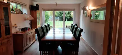 a dining room with a wooden table and chairs at Woodlands Peaceful Bedrooms in Hemingford Grey