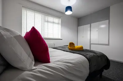 a large bed with a yellow stuffed animal sitting on it at Suffolk Square in Sudbury