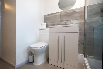 a white bathroom with a toilet and a shower at Suffolk Square in Sudbury
