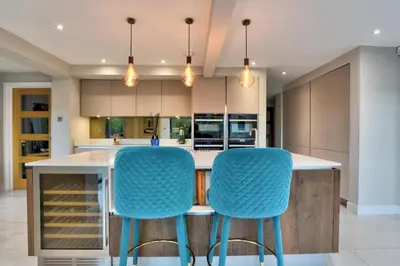 a kitchen with blue chairs at a kitchen island at Stunning large house in Green Dunmow in Felsted