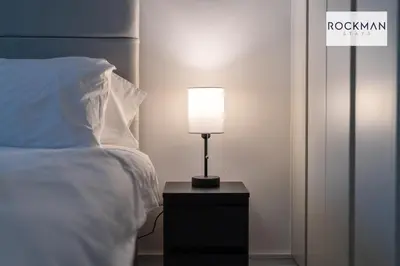 a lamp on a night stand next to a bed at Library House Apartments - FREE PARKING - Contractor Hub - Superfast Wi-Fi - Long Term Stays in Brentwood