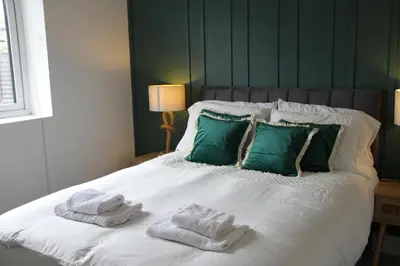a bedroom with a bed with towels on it at Colchester town and castle modern flat with kitchen & private parking in Hythe