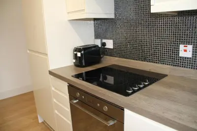 a kitchen with a stove and a counter top at Colchester town and castle modern flat with kitchen & private parking in Hythe
