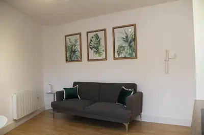 a living room with a couch and three pictures on the wall at Colchester town and castle modern flat with kitchen & private parking in Hythe