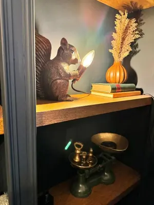 a wooden rat on a shelf with a magnifying glass at The Green Scholar's Nook in Cambridge