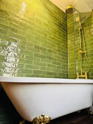 a green tiled bathroom with a tub and a shower at The Green Scholar's Nook in Cambridge