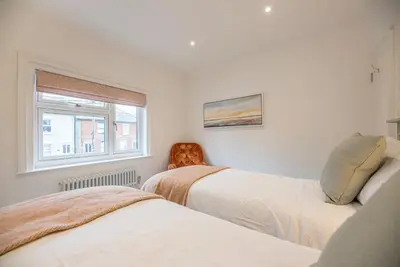 a bedroom with two beds and a window at Millicent Cottage, Aldeburgh in Aldeburgh